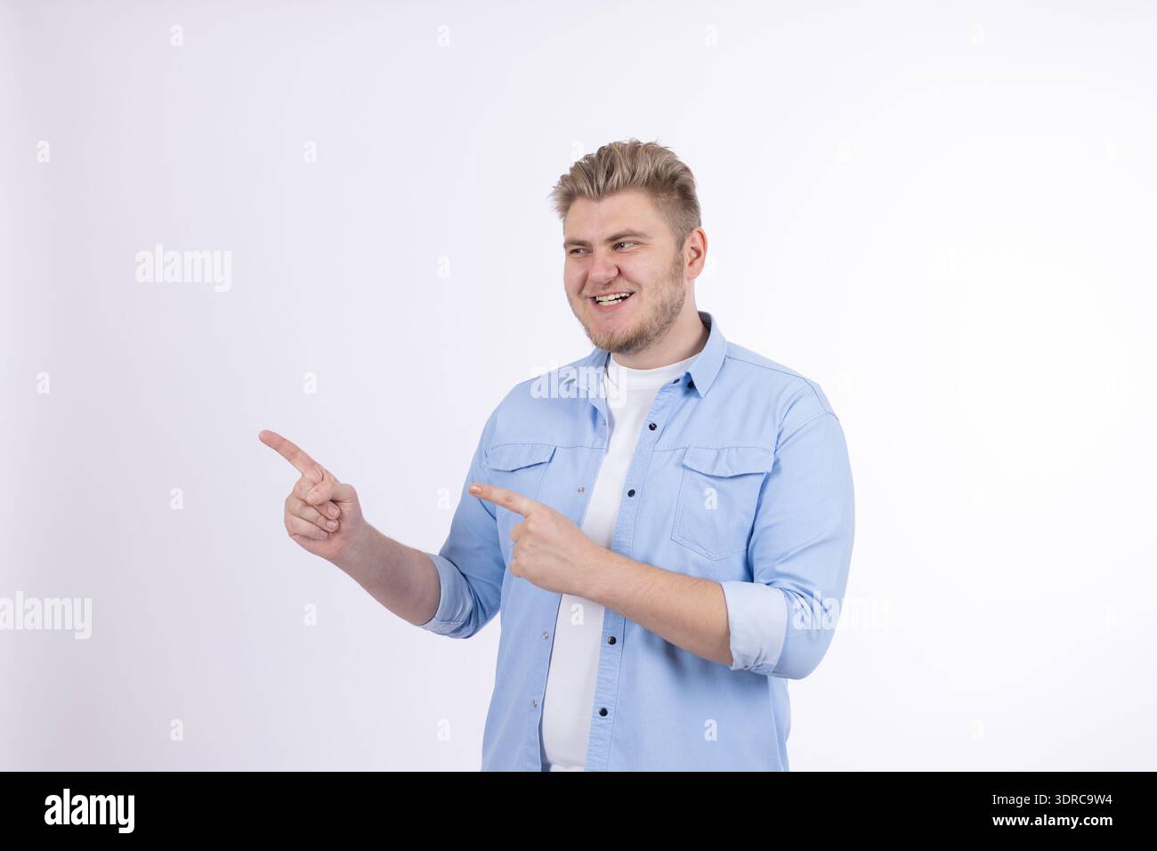 Mann in blauem Hemd, der mit einer Hand zur Seite zeigt Stockfoto