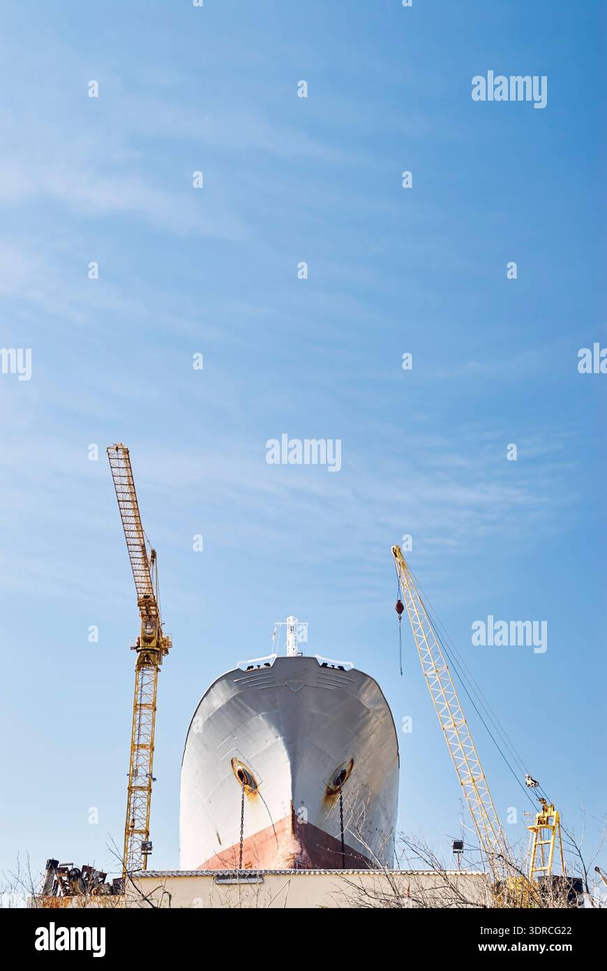 Schiffsreparaturindustrie: Altes Frachtschiff wird in der Werft repariert. Maschinen: Schiffskrane Stockfoto