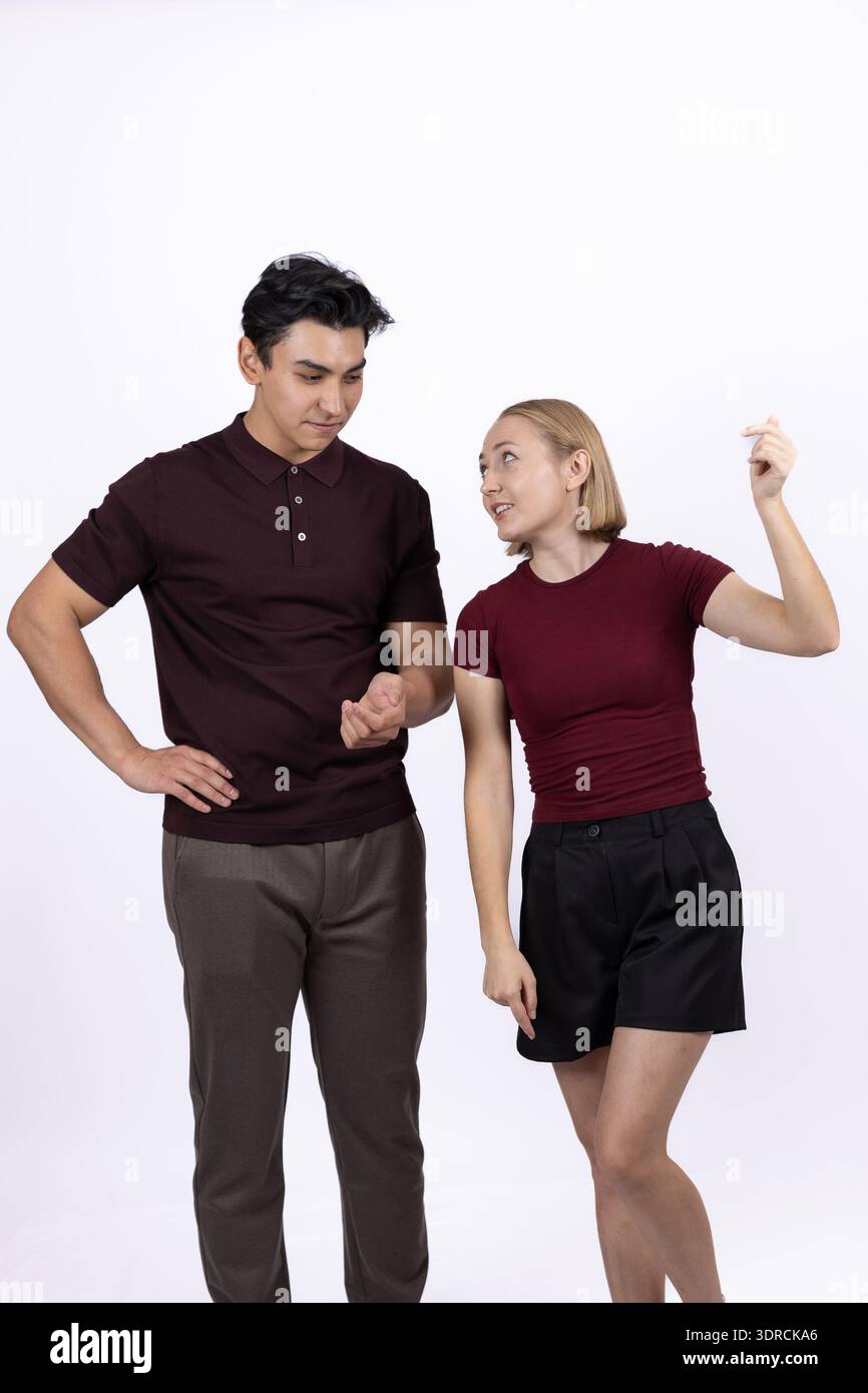 Mann und Frau in dunkler Kleidung, die zusammen im Studio lachen Stockfoto