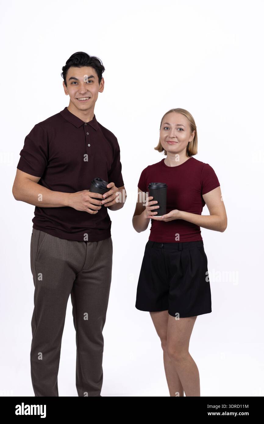Junger Mann und Frau, die gemeinsam im Studio Smartphones benutzen Stockfoto