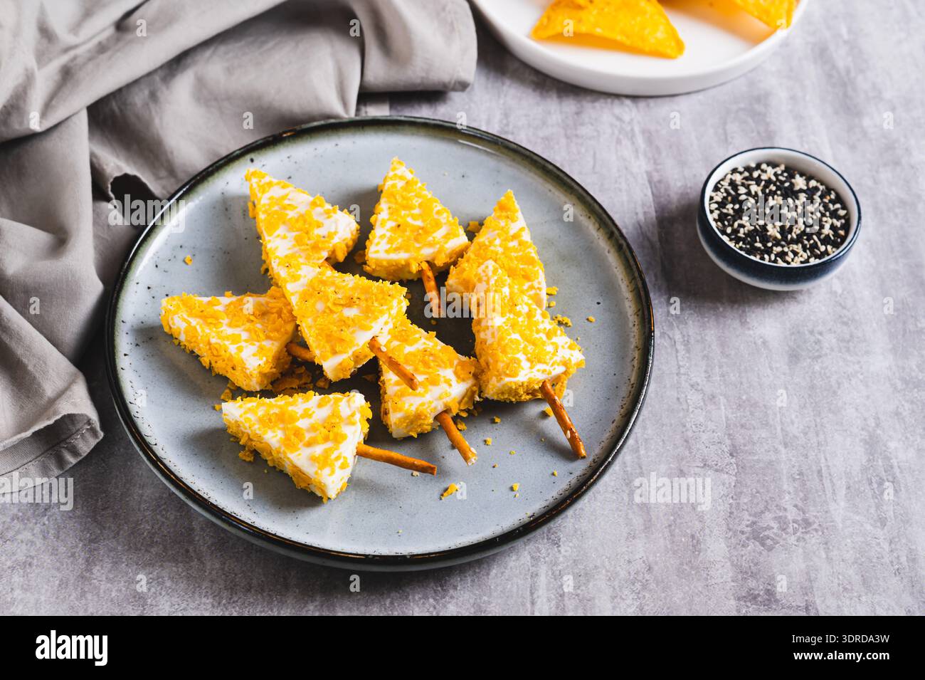 Weihnachtsbäume aus Käse und Nachos auf einem Teller auf einem Tisch Stockfoto