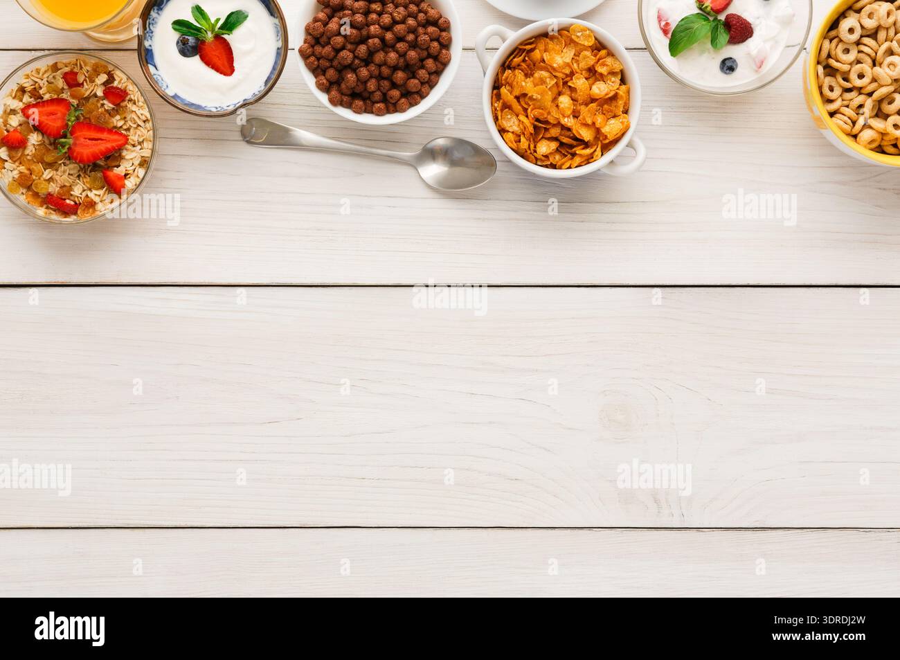 Frühstückssammlung mit Müsli und Obst auf einem Holztisch in einer Küche Stockfoto