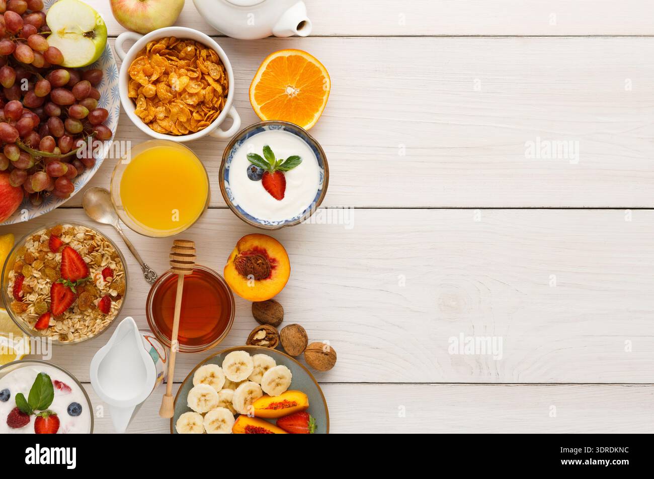 Frühstückskollektion mit Obst, Müsli und Getränken auf einem einfachen Tisch Stockfoto
