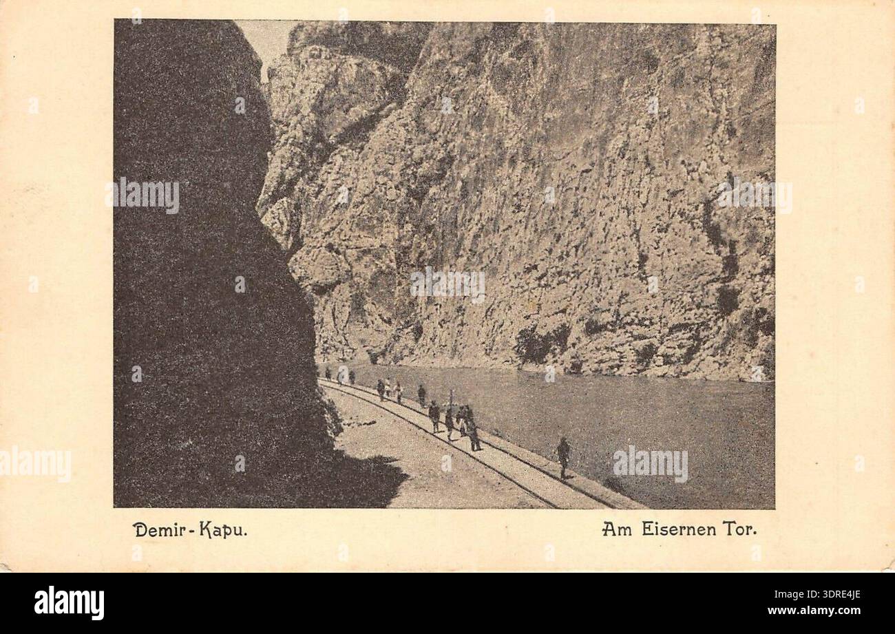 Diese Postkarte aus dem Jahr 1916 zeigt die Eisenbahn, die durch den Demir Kapija Canyon entlang des Vardar River in Nordmazedonien führt. Das Bild zeigt die Schiene, Brücken, Canyonwände und die umliegende natürliche Umgebung. Es dokumentiert Eisenbahntechnik, Verkehrsnetze und Landschaftsinteraktionen des frühen 20. Jahrhunderts und liefert historische Beweise für die Entwicklung der Infrastruktur, die baulichen Praktiken und die geographischen Merkmale des Balkans während dieser Zeit. Stockfoto