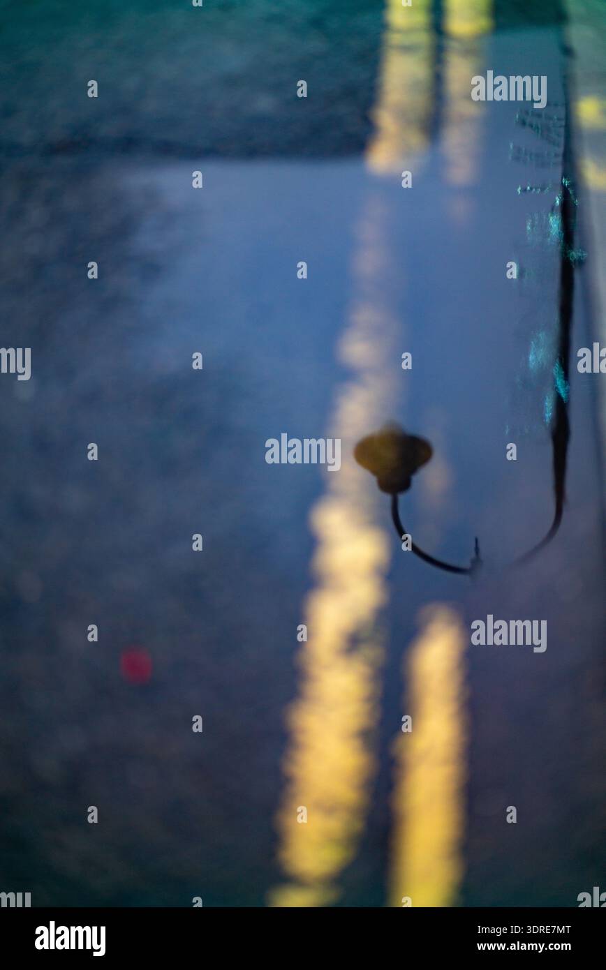 Straßenlaterne-Reflexion in der Regenpfütze Stockfoto