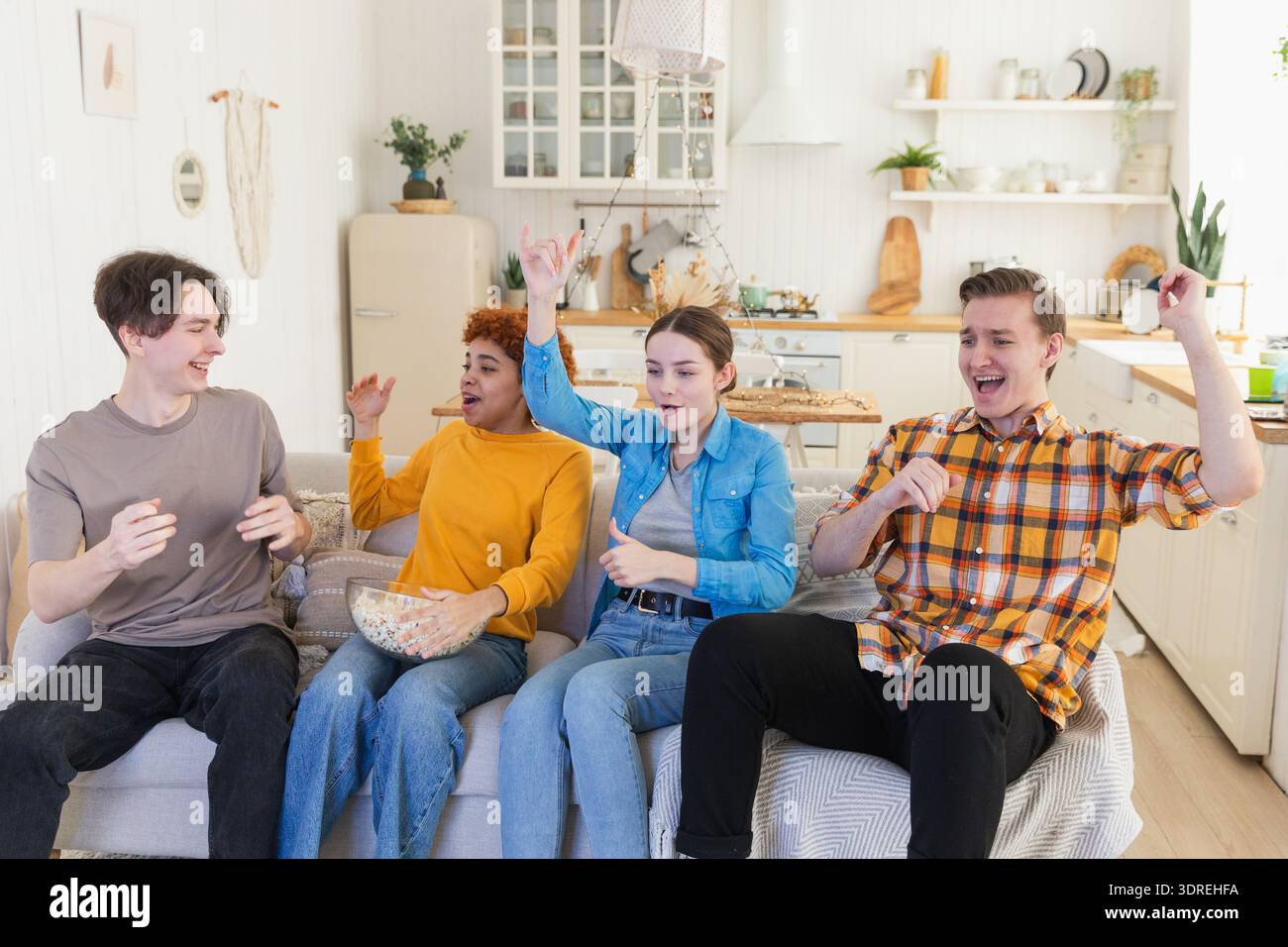 Eine Gruppe von Freunden, die sich ein Fußballspiel im fernsehen anschauen. Glückliche Fußballfans feiern zu Hause den Sieg. Freundschaft sp Stockfoto