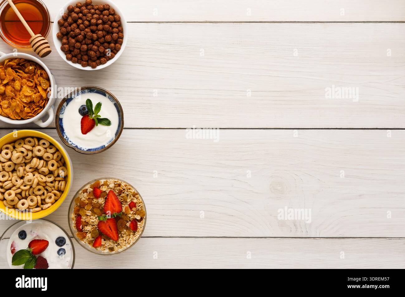 Verschiedene Frühstücksartikel in einer farbenfrohen Kollektion auf einer hölzernen Tischfläche angeordnet Stockfoto