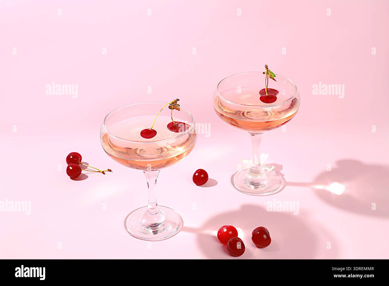 Modernes Stillleben mit Rosenwein, alkoholischem Cocktail und Kirschbeeren auf elegantem, modernem Hintergrund, minimales Konzept für Bar und Stockfoto