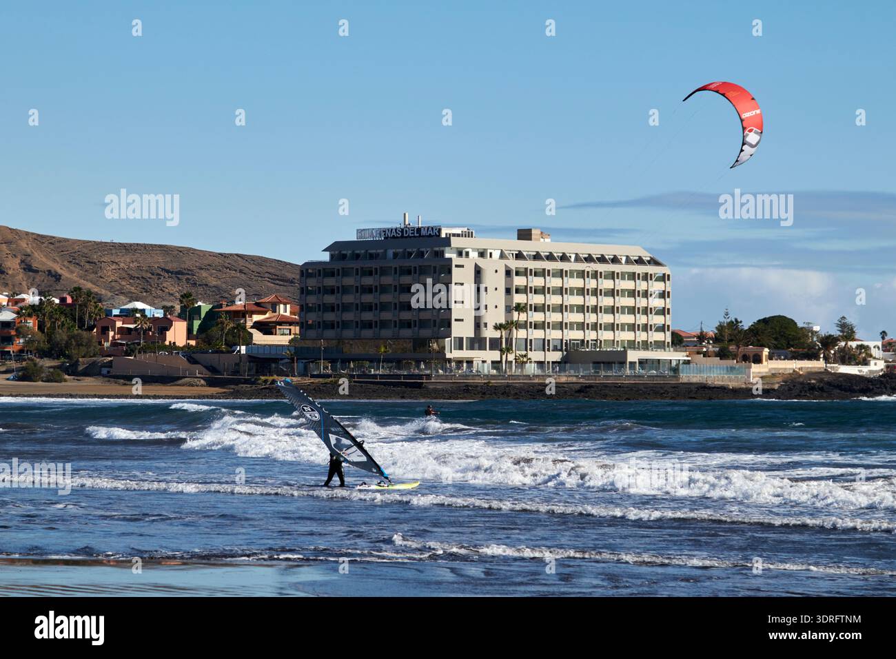 Kitesurfer und Windsurfer in den Wellen vor dem Arenas del mar Hotel el medano teneriffa kanarische Inseln spanien Stockfoto