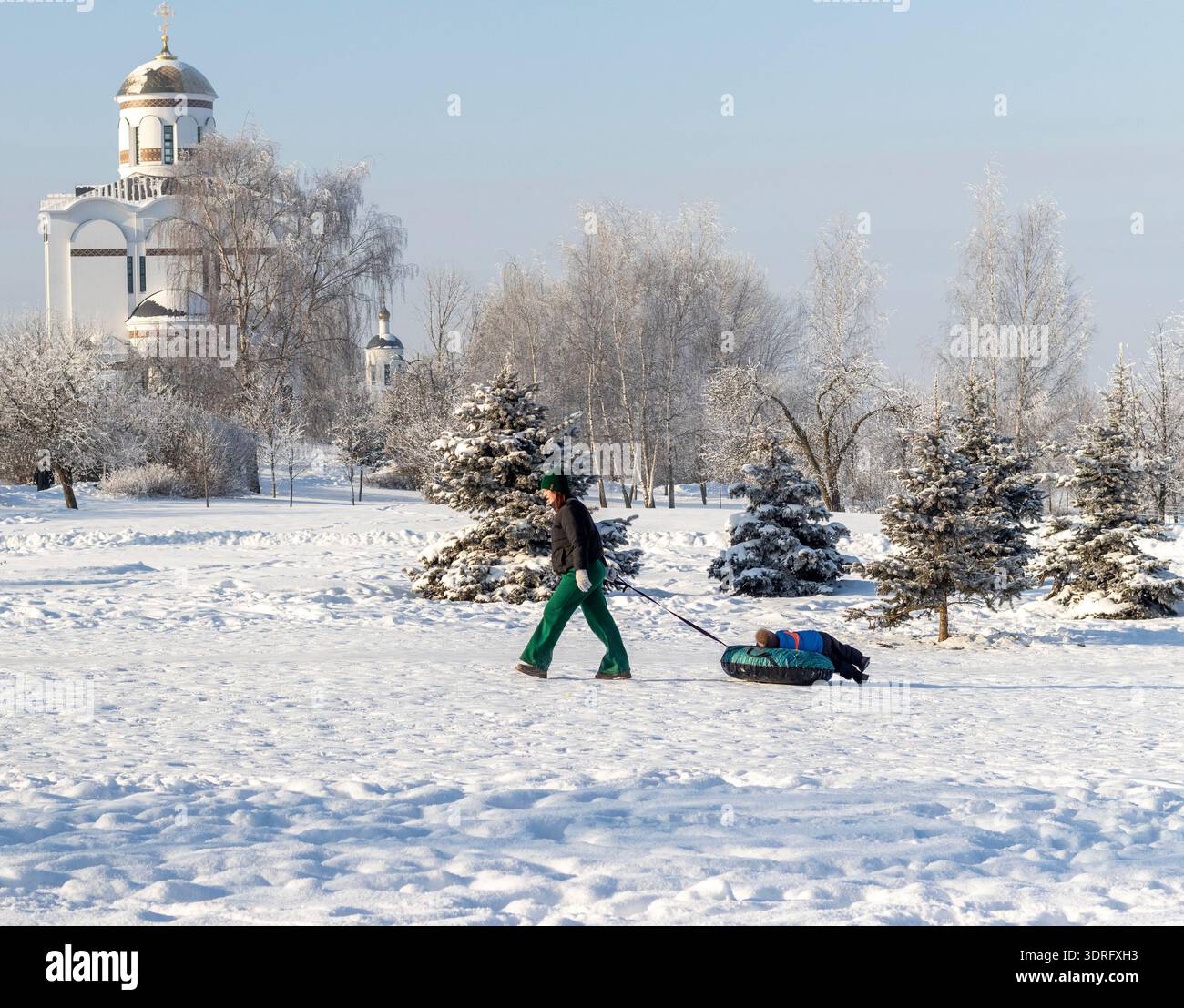 02.02.2026 - Minsk, Weißrussland - Ein friedlicher Wintertag in einem schneebedeckten Park, bei dem Mutter und Sohn Spaß haben Stockfoto