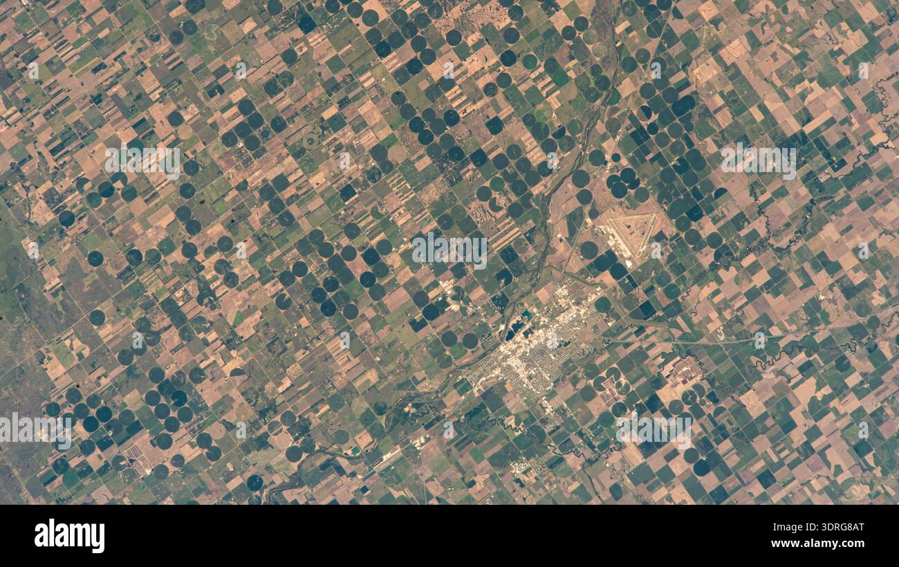 Great Bend, Kansas, die Erde aus dem Orbit, Vereinigte Staaten von Amerika, hauptsächlich eine landwirtschaftliche Stadt und an der Stelle gelegen, an der sich der Kurs des Arkansas River verlagert, ist von der Internationalen Raumstation aus abgebildet, die 261 Meilen über dem Sunflower State umkreist. Der dreieckige Great Bend Municipal Airport, der einst als Basis für die B-29 Superfortress während des Zweiten Weltkriegs genutzt wurde und heute für die allgemeine Luftfahrt genutzt wurde, ist ebenfalls zu sehen. Ein Foto von der Internationalen Raumstation am 18. August 2025. Eine optimierte Version eines Originalbildes der NASA: Credit NASA Stockfoto