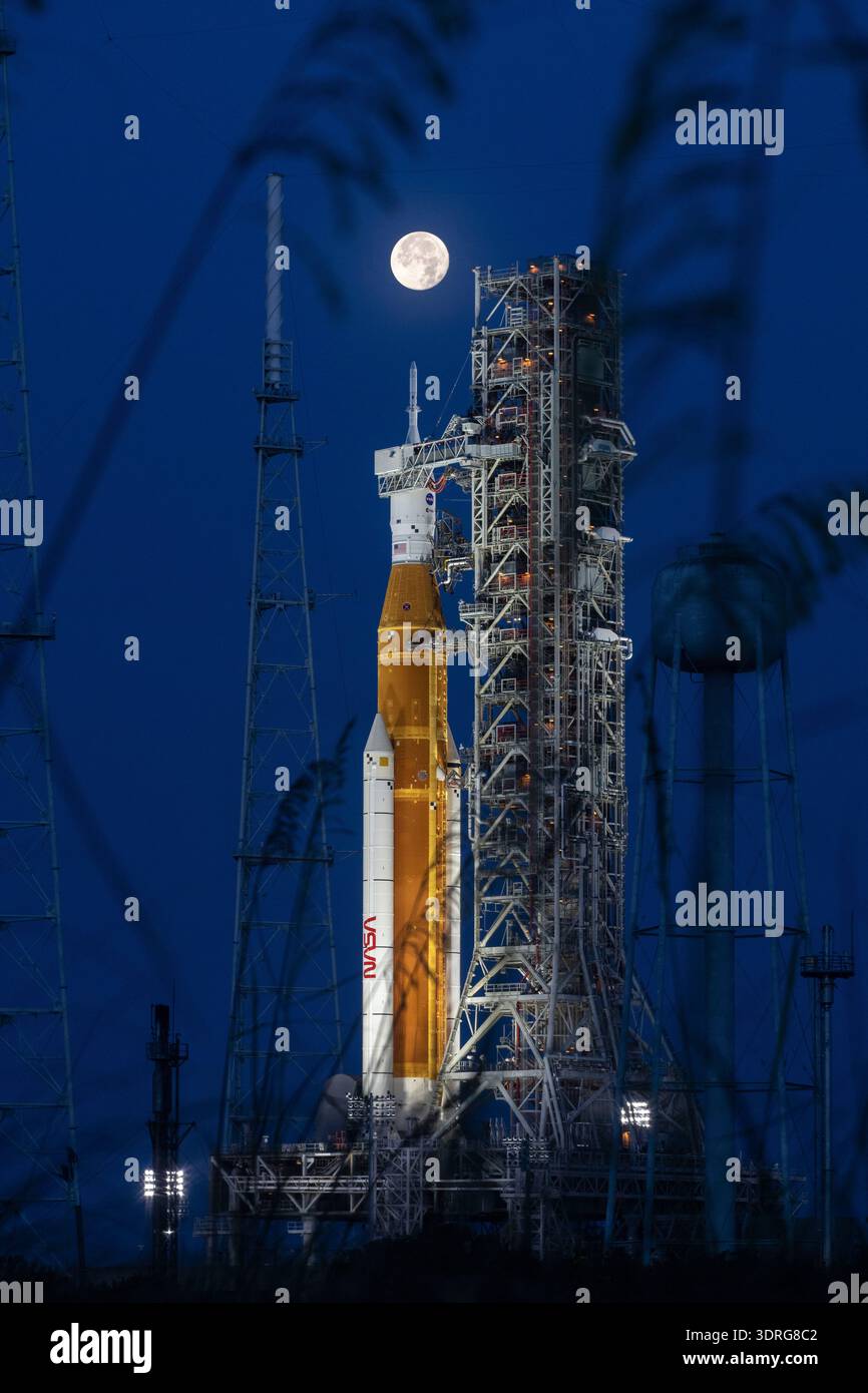 Am 14. Juni 2022 ist ein Vollmond vom Launch Complex 39B im Kennedy Space Center der NASA in Florida zu sehen. Das Artemis I Space Launch System (SLS) und die Orion Raumsonde auf dem mobilen Trägerraketen werden auf eine Probe vorbereitet, um Zeitpläne und Verfahren für den Start zu üben. Artemis I wird SLS und Orion als integriertes System vor den bemannten Flügen zum Mond testen. Eine optimierte Version eines Originalbildes der NASA: Credit NASA Stockfoto