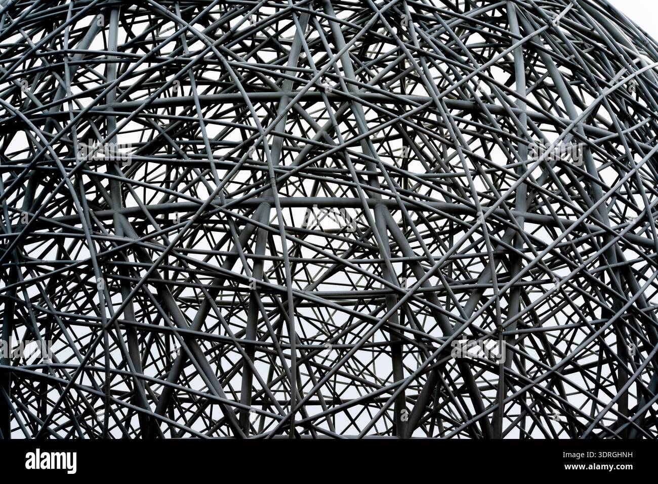 Metallskulpturenstruktur mit kompliziertem geometrischem Gitterdesign vor bewölktem Himmel Stockfoto