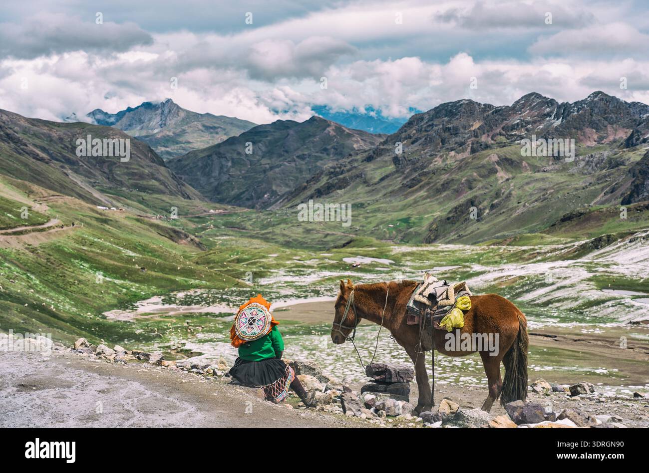 Einheimische peruanische Frau in traditioneller Kleidung ruht neben einem Pferd mit der atemberaubenden Gletscherlandschaft der Vilcanota Bergkette im Hinterland Stockfoto
