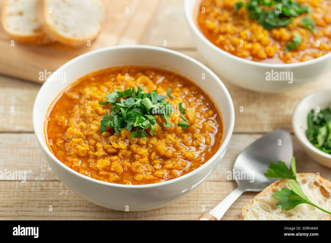 Scharfe vegane Linsensuppe in weißer Schüssel Stockfoto