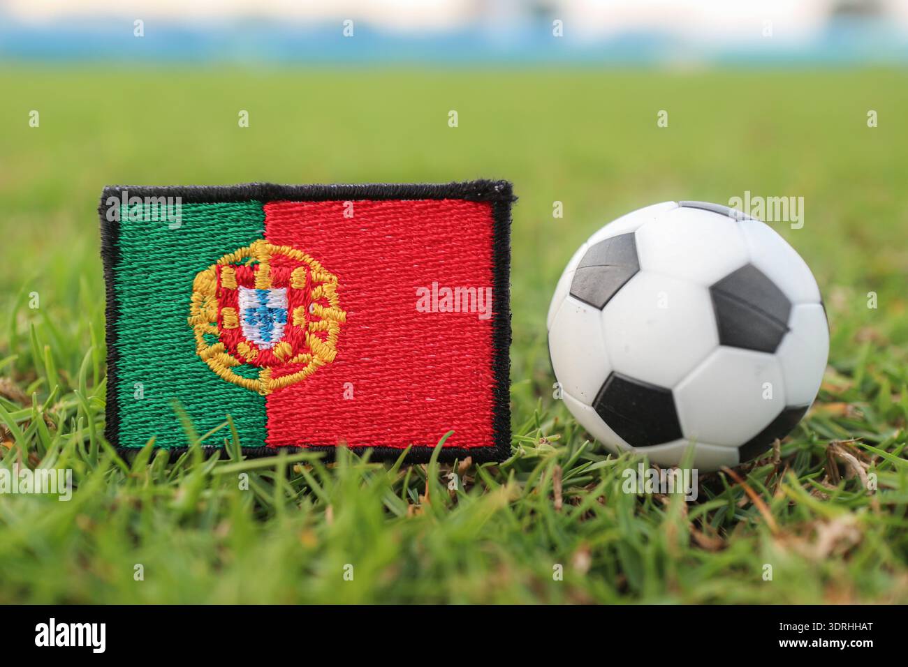 Portugal Flagge und Fußball auf Stadionrasen. Professionelle visuelle Darstellung für Nachrichten über Weltturniere, Fanenergie und internationales Sportmarketing. Stockfoto
