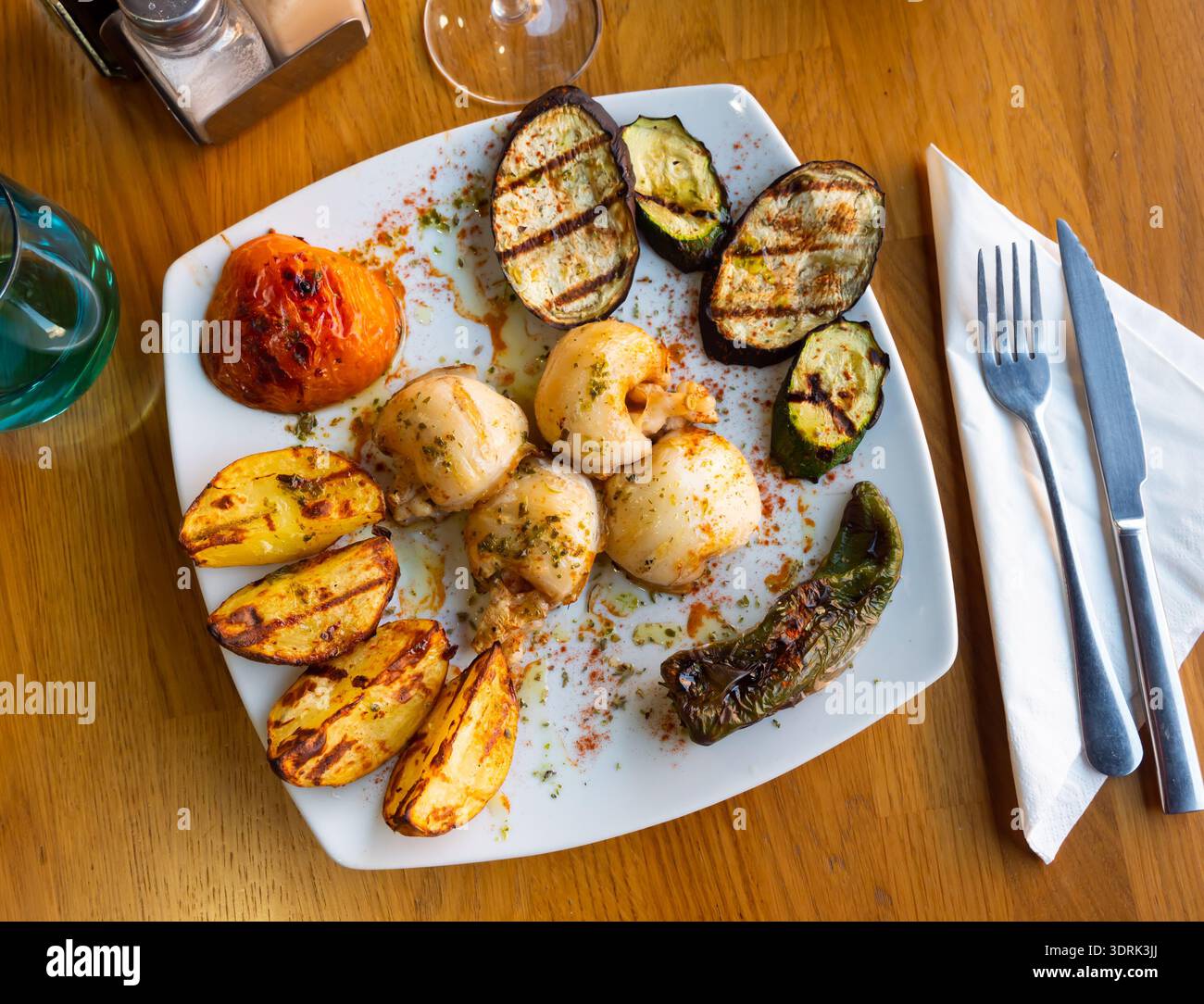 Köstlicher gebratener Tintenfisch mit gegrilltem Gemüse auf Teller Stockfoto