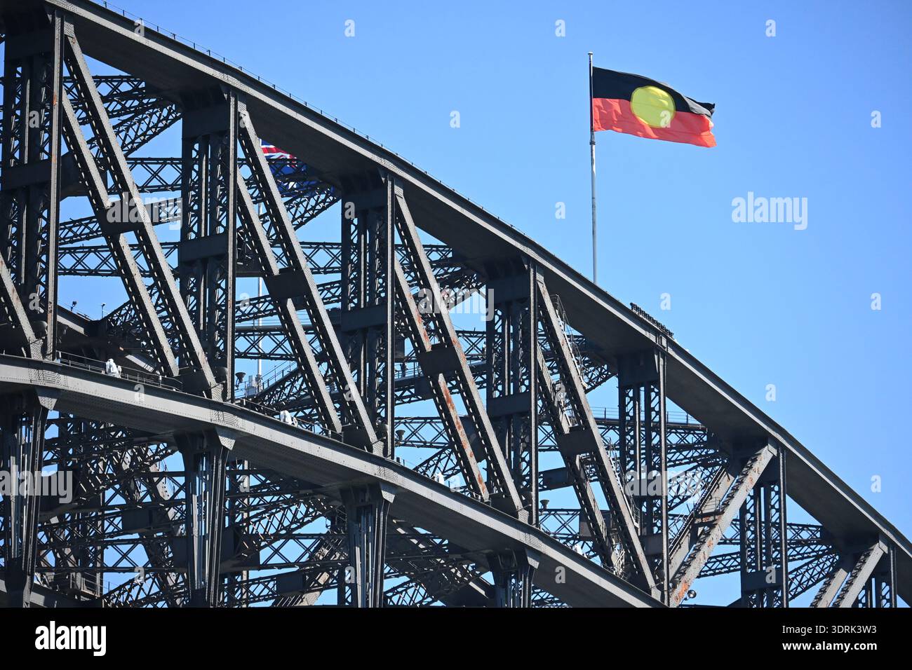 SYDNEY – 29. Dezember 2025: Die australische Aborigines-Flagge auf der Sydney Harbour Bridge Sydney NSW Australia. Entworfen von Harold Thomas im Jahr 1971, ist eine mächtige Sym Stockfoto