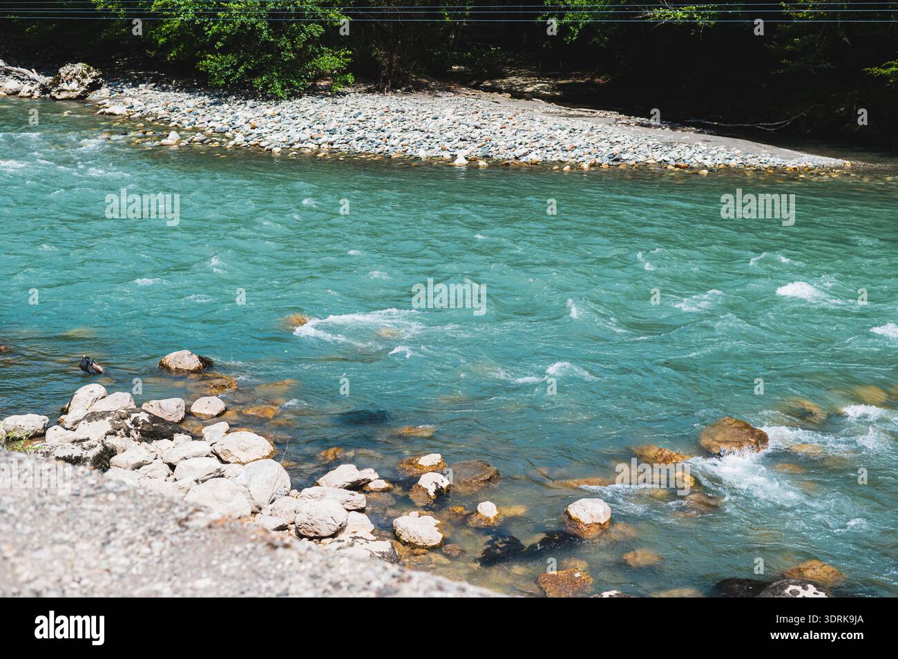 An einem Sommertag fließt ein Gebirgsbach über Felsen Stockfoto