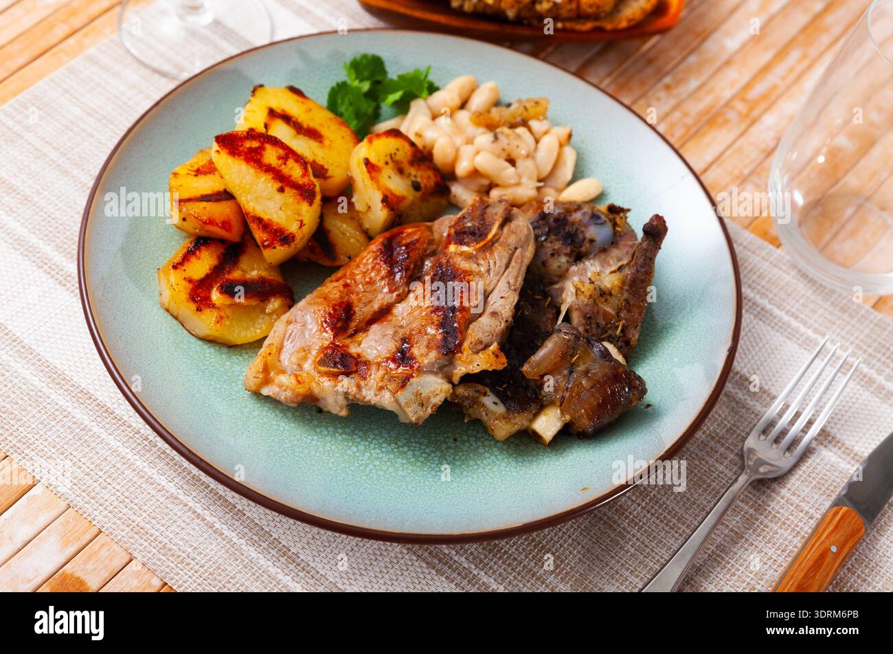 Gebratenes Lamm mit Bohnen und halber Kartoffel. Stockfoto
