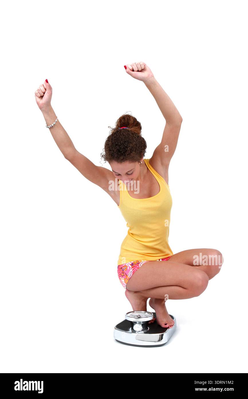 Junge Frau auf der Personenwaage Stockfoto