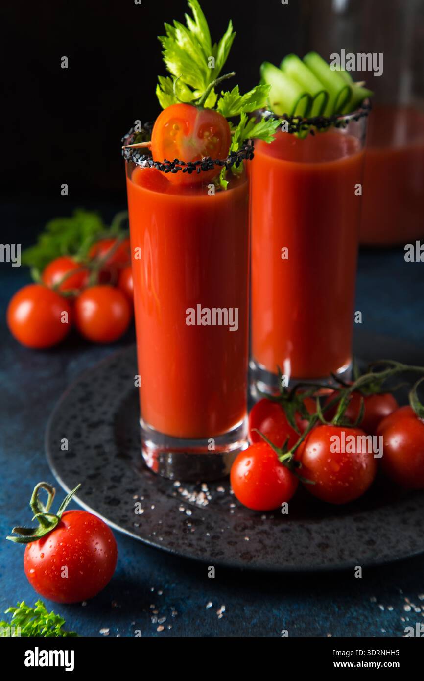 Gläser Tomatensaft serviert mit Gurke und Sellerie Stockfoto
