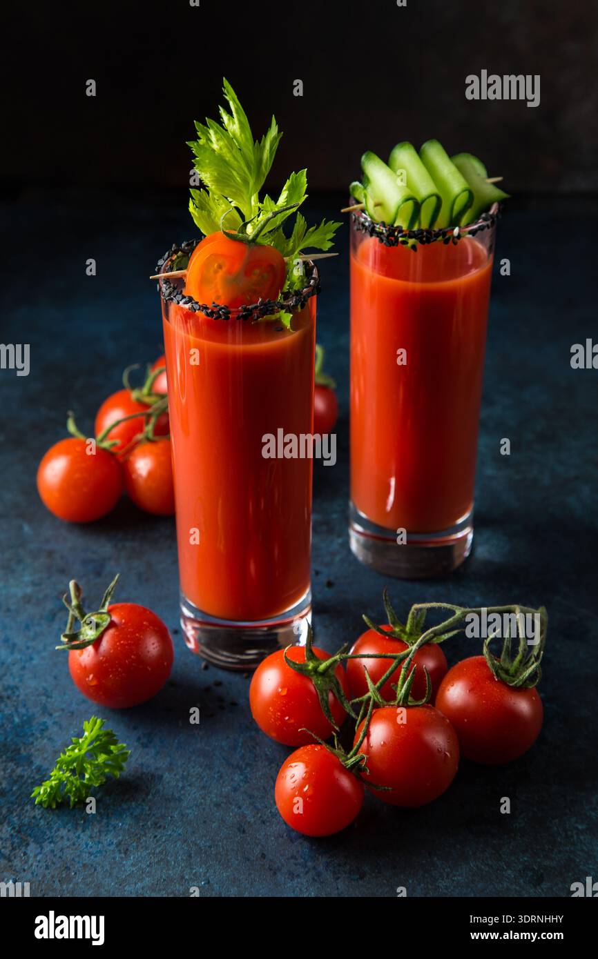 Gläser Tomatensaft serviert mit Gurke und Sellerie Stockfoto
