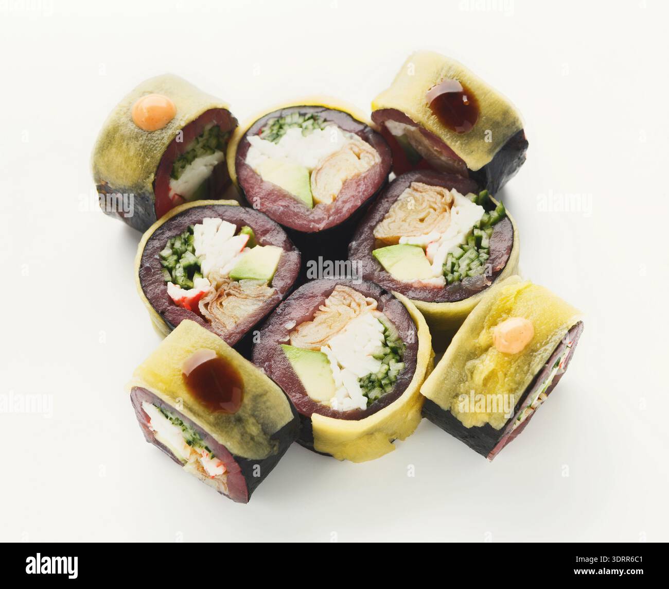 Collage von Sushi Rolls in einem kreativen Set mit verschiedenen Füllungen auf einem sauberen Hintergrund Stockfoto