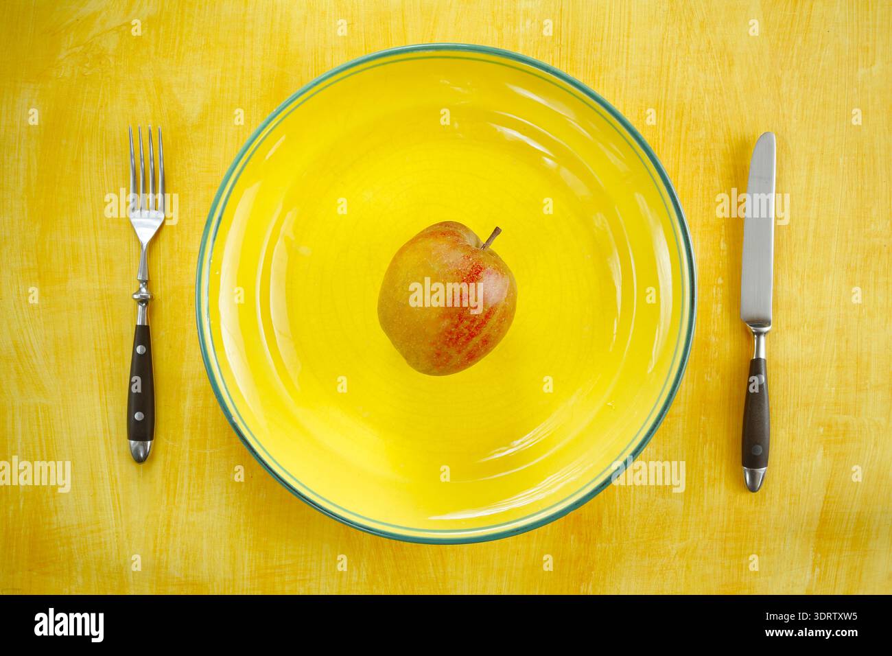 Diät- und Gewichtsreduktionskonzept, Teller mit Besteck und einem Apfel Stockfoto