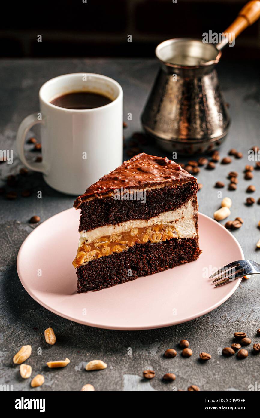 Schokoladenkuchenscheibe mit Sahne und Erdnüssen Stockfoto
