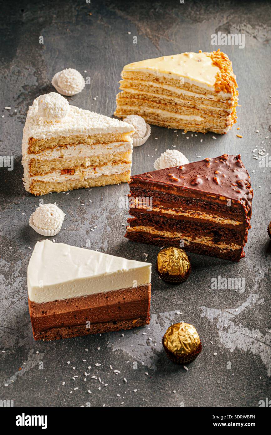Gemischte Kuchen auf dunklem Steintisch Stockfoto