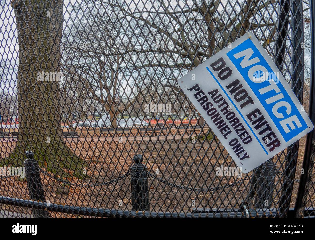 Schwarzer Maschendrahtzaun um einen Park Stockfoto