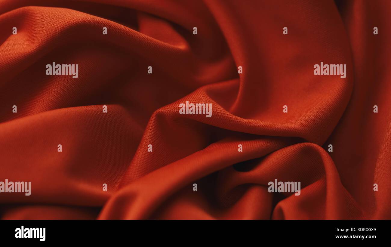 Glattes und elegantes rotes Synthetik-Material mit weichen fließenden Falten und dezenter matter Textur. Nahaufnahme. Stockfoto