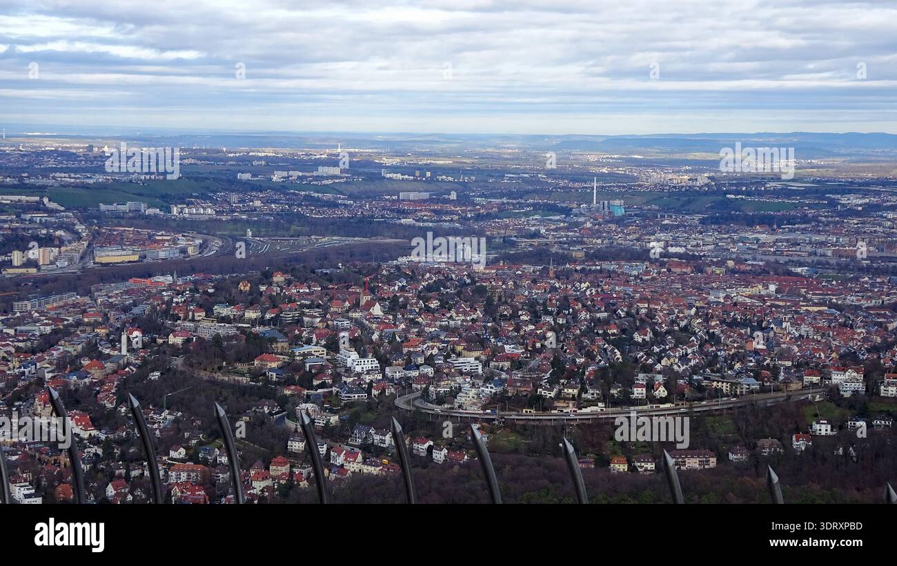 Luftaufnahme einer dicht bebauten Stadt, umgeben von Hügeln und natürlicher Landschaft, zeigt den Kontrast zwischen städtischen und ländlichen Gebieten. Stockfoto