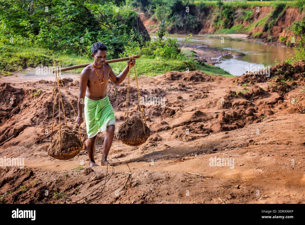 Mann sammelt Sand aus einem Fluss, Odisha, Indien Stockfoto