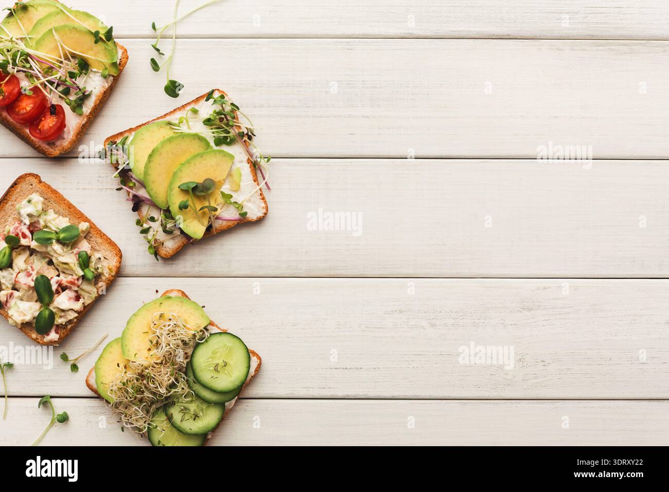 Sammlung gesunder Snacks mit frischem Gemüse und Toppings auf geröstetem Brot Stockfoto