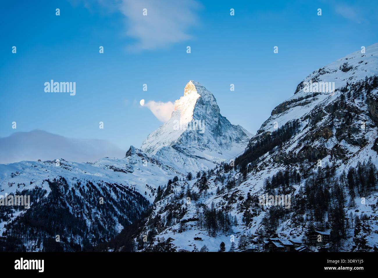 Matterhorn bei Sonnenaufgang über Zermattal mit Mond im Winter Stockfoto