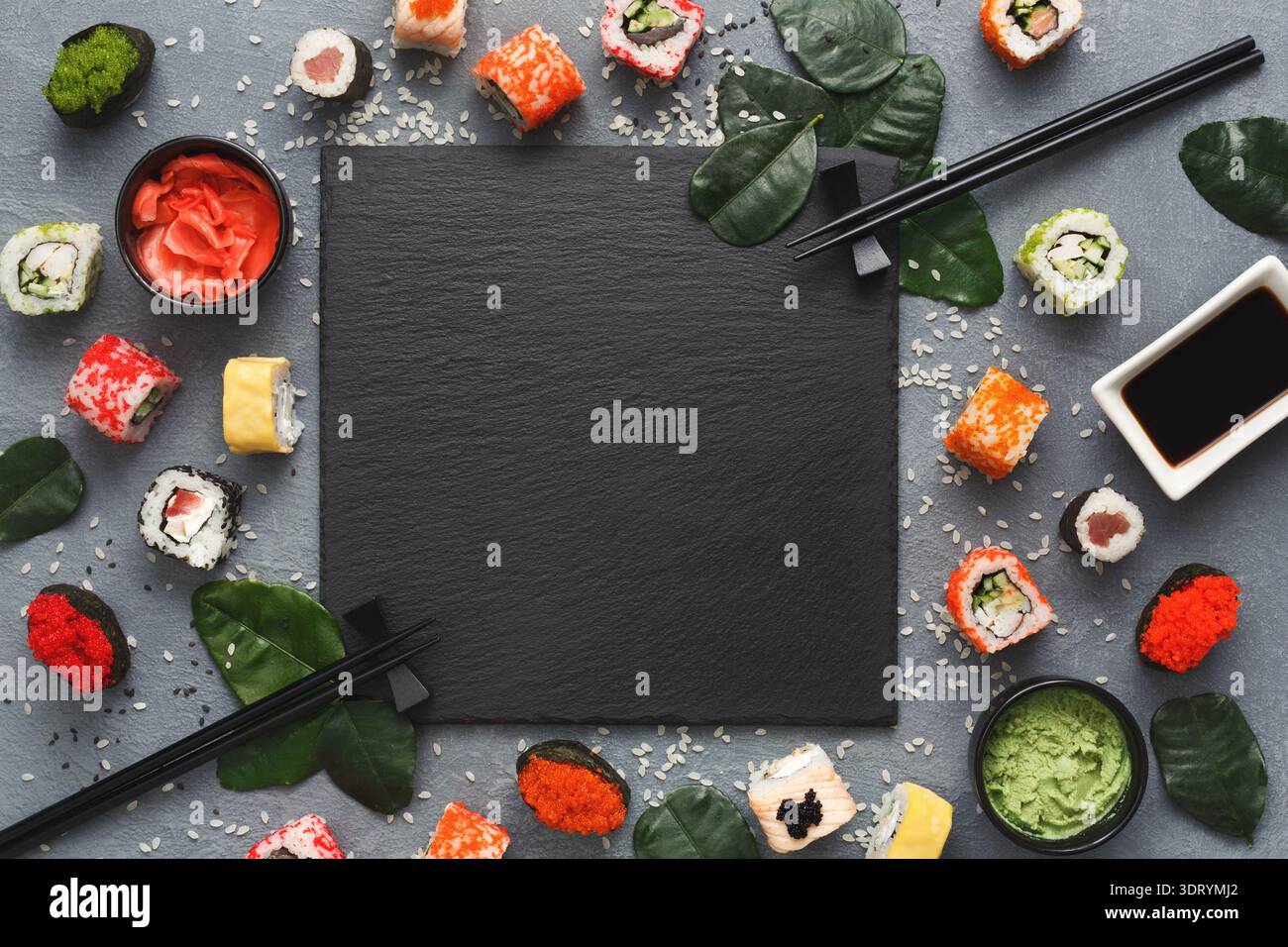 Sushi-Rollen und Würzmittel auf einer flachen Oberfläche mit Platz zum Schreiben Stockfoto