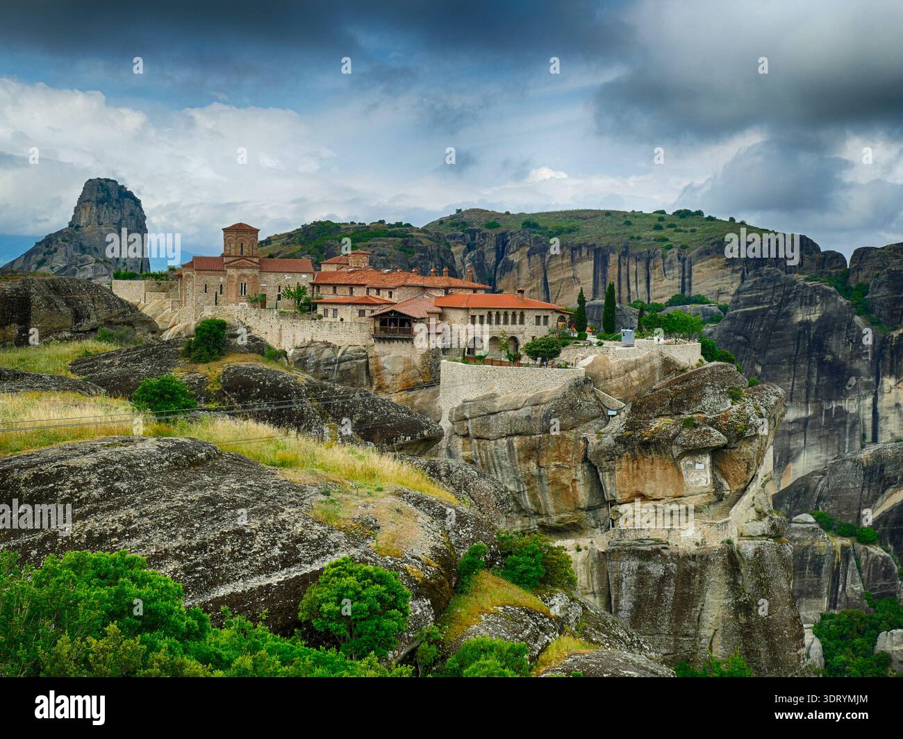 METERORA, GFEECE - 11. MAI 2025 - das Kloster Varlaam thront auf einem felsigen Gipfel inmitten der dramatischen Landschaft von Meteora, Griechenland, überragt von der Wolke Stockfoto