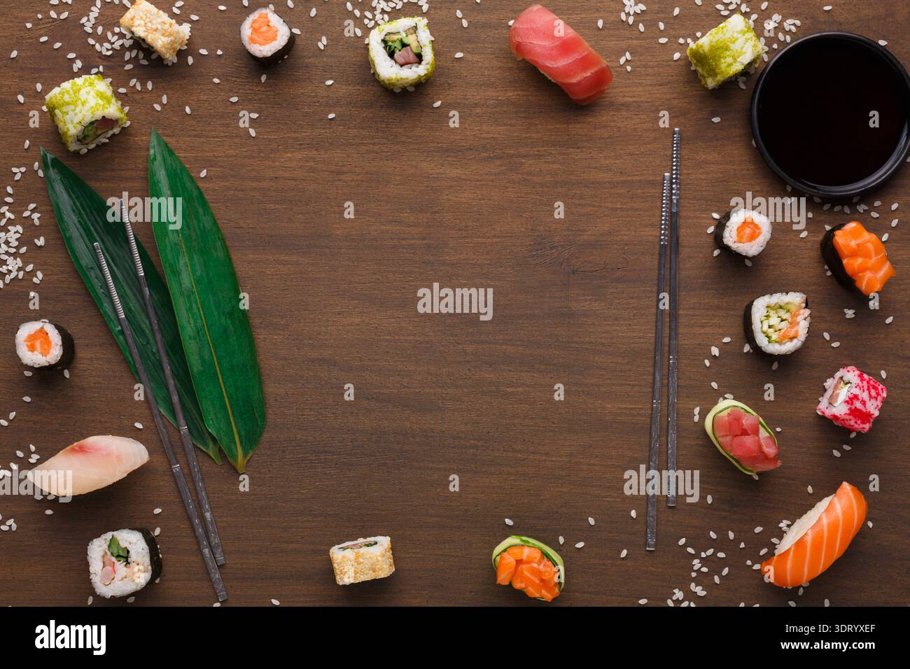 Sammlung von Sushi-Stücken auf Holzoberfläche mit Essstäbchen und Sojasauce Stockfoto