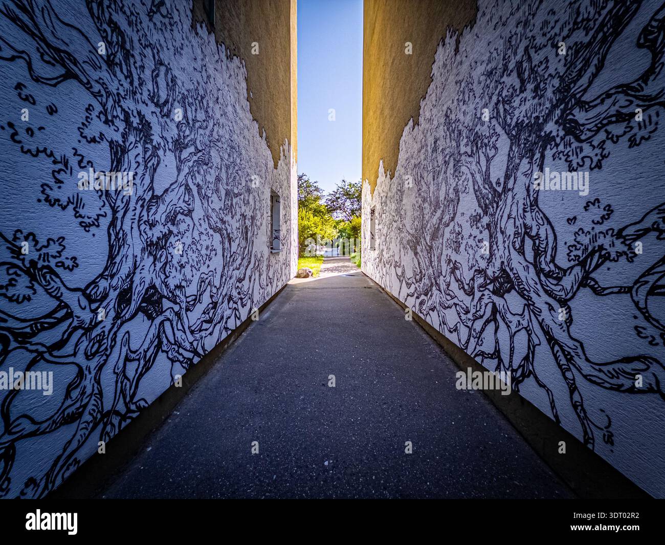 Symmetrischer Korridor mit Baumgemälden, der zum Garten führt, Warschau Polen Urban Street Art - Smartphone-aufgenommenes Stockfoto