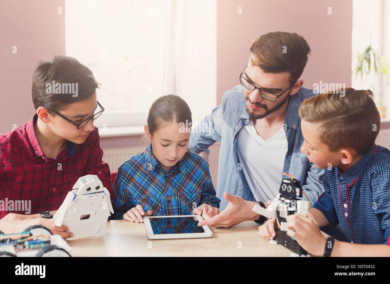 Kinder erfahren tagsüber mehr über Robotik und Programmierung mit einem Tablet im Klassenzimmer Stockfoto