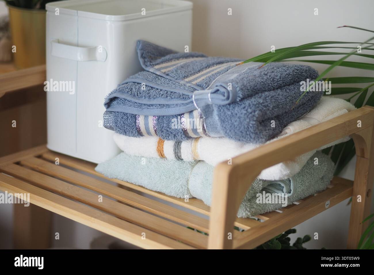 Handtücher stapelten sich auf Holzregalen in einem ruhigen Innenraum Stockfoto