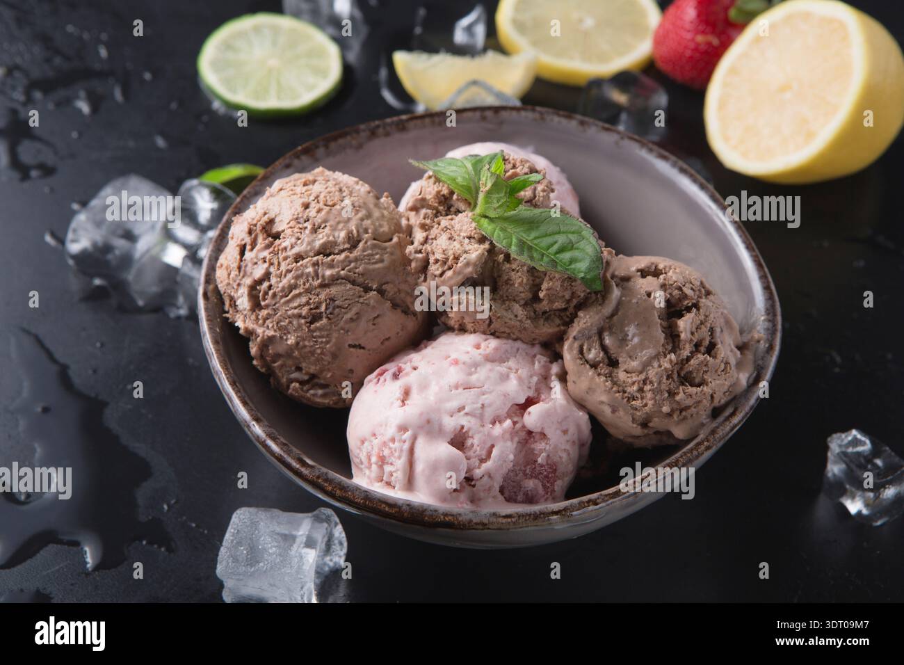 Verschiedene Geschmacksrichtungen von Eis serviert in einer Schüssel mit Obst und Eis Stockfoto