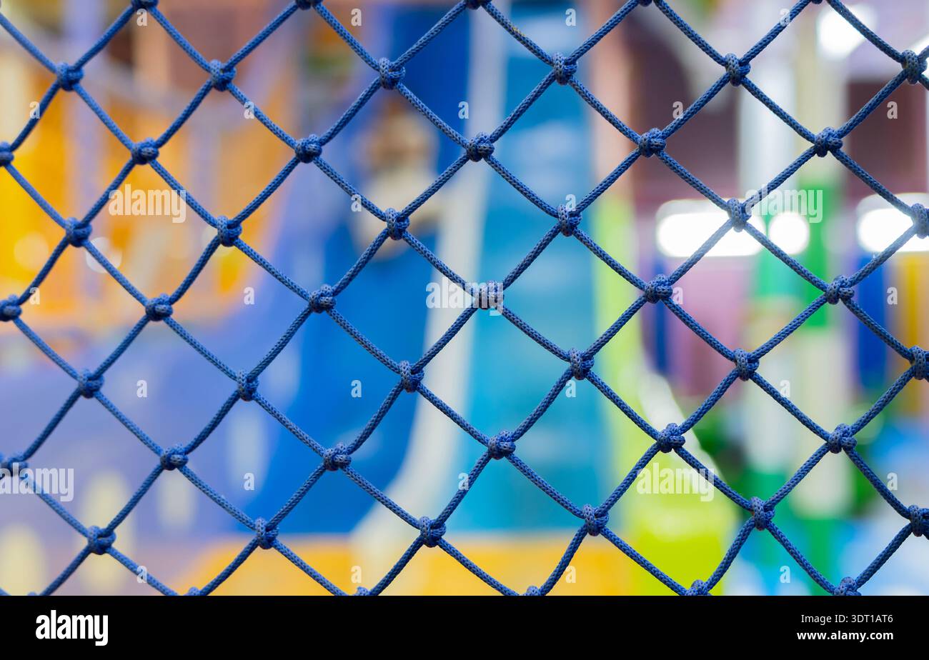 Nahaufnahme des blauen Sicherheitsnetzes auf dem Spielplatz auf dem Spielplatz. Kinderspielplatz Sicherheitsnetz aus nächster Nähe. Stockfoto