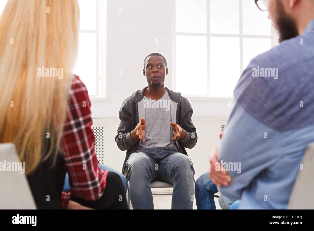 Gruppendiskussion zum Thema Persönliches Wachstum während eines Workshops in einem hellen Raum Stockfoto