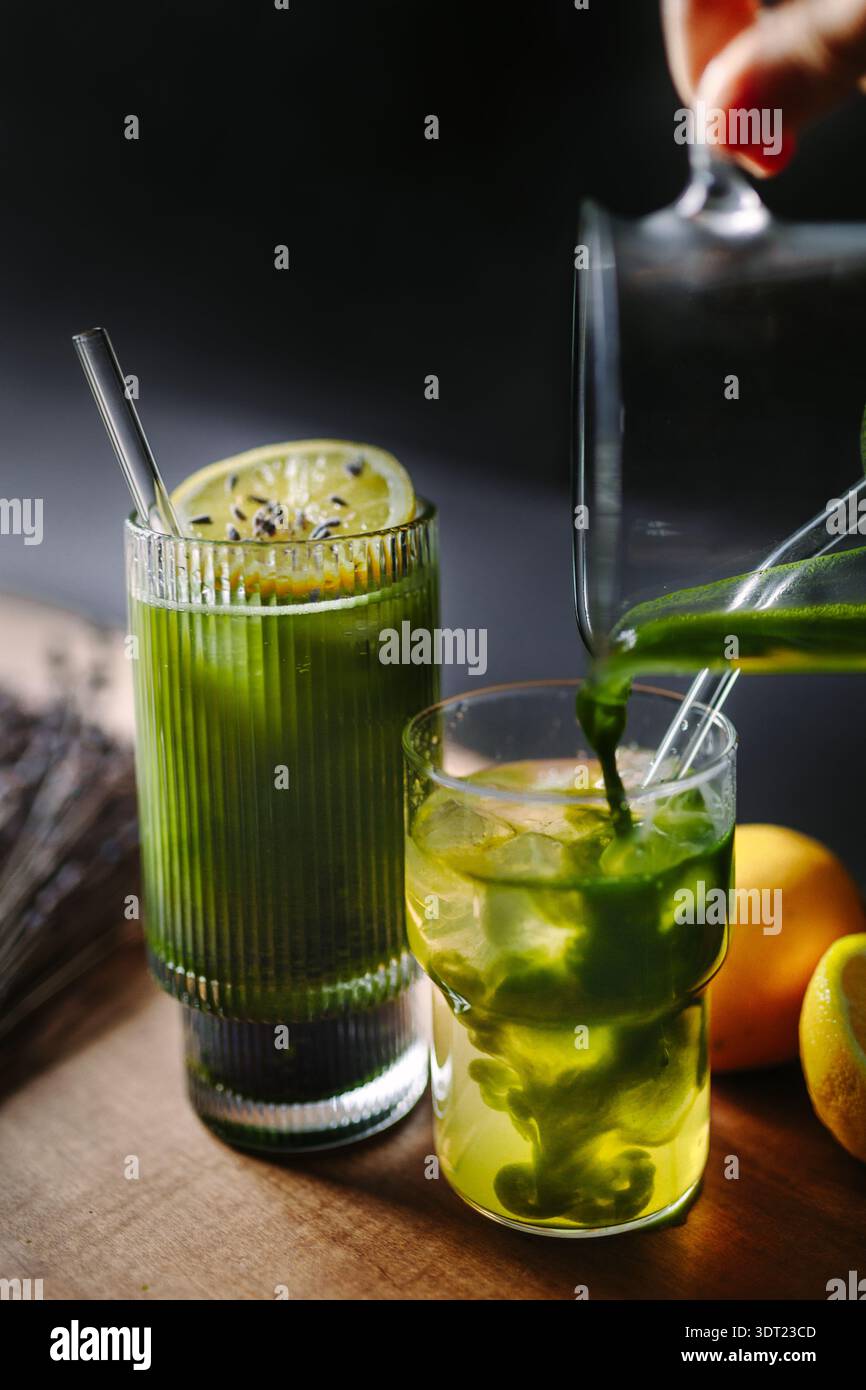Ein lebhaftes Matcha- und Zitrusgetränk mit erfrischender Limettengarnitur, wunderschön präsentiert in hohen Gläsern. Die perfekte Mischung aus Aromen für einen Revitalizi Stockfoto
