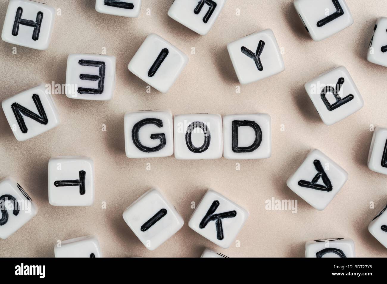 Kleine weiße und schwarze Perlenwürfel auf einem Brett, Buchstaben in der Mitte buchstabieren GOTT Stockfoto