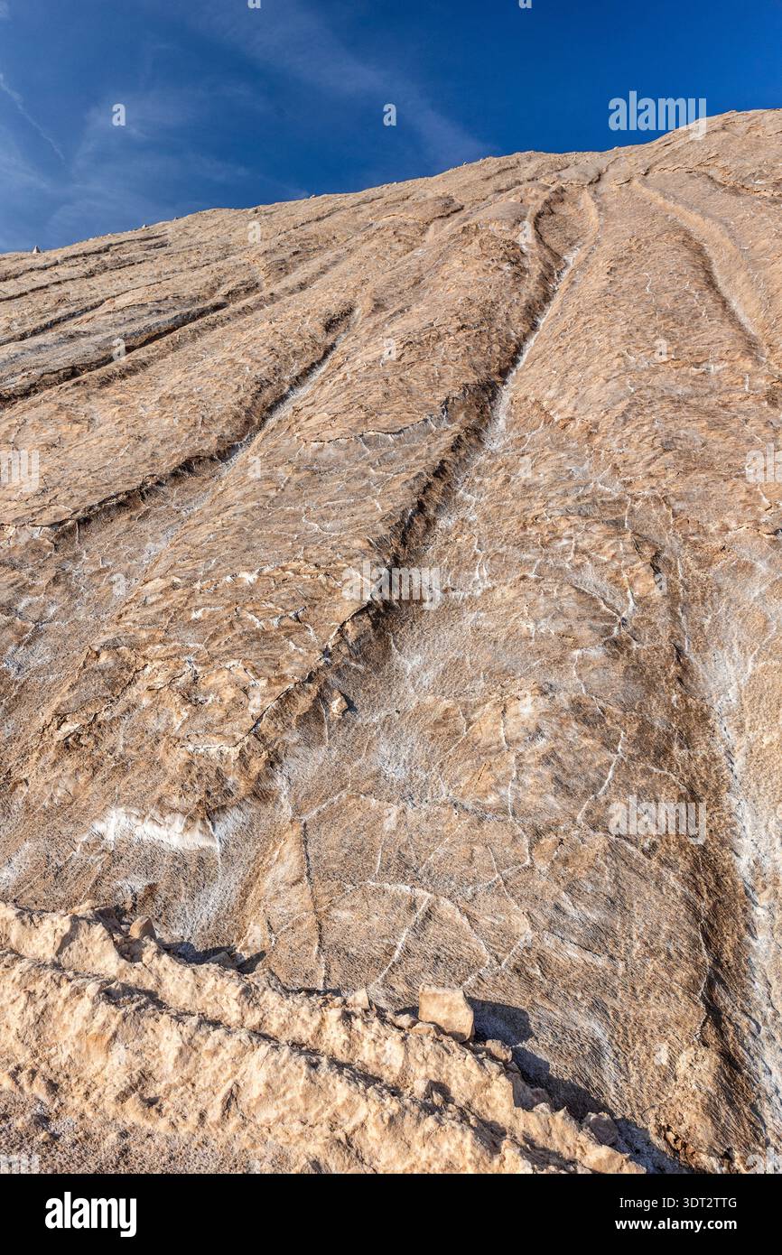 Industrieminenhütte steiler Mineralhang, Schichtstrukturen Erosion Spuren roher Geologie klarer blauer Himmel. Die Szene zeigt die Gewinnung von Bergbaueinschlägen Stockfoto