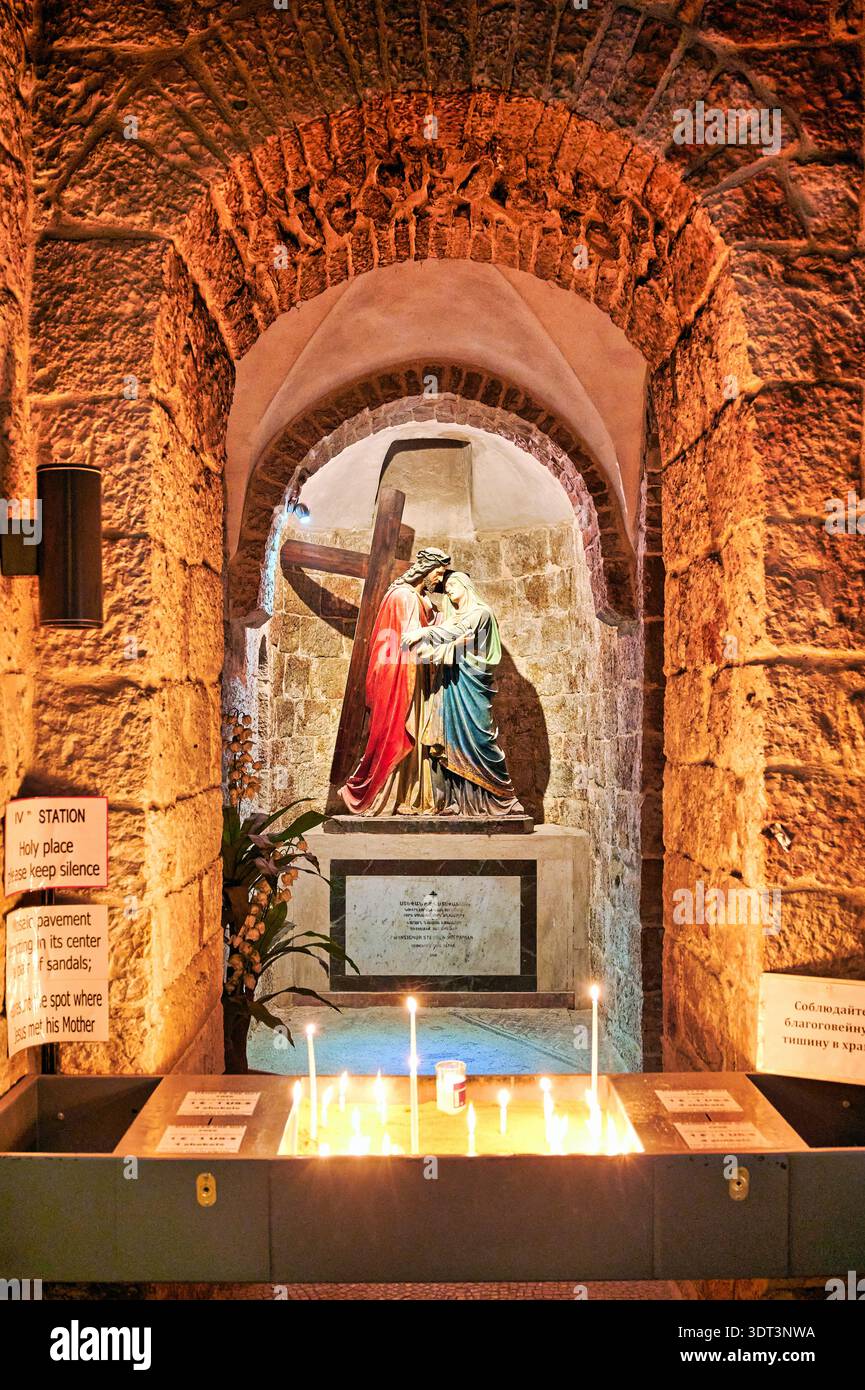 Eine Statue von Maria und Jesus ist in einer kleinen Kapelle. Vor der Statue werden Kerzen angezündet. Das Hotel ist ruhig und hat Steinmauern. Stockfoto